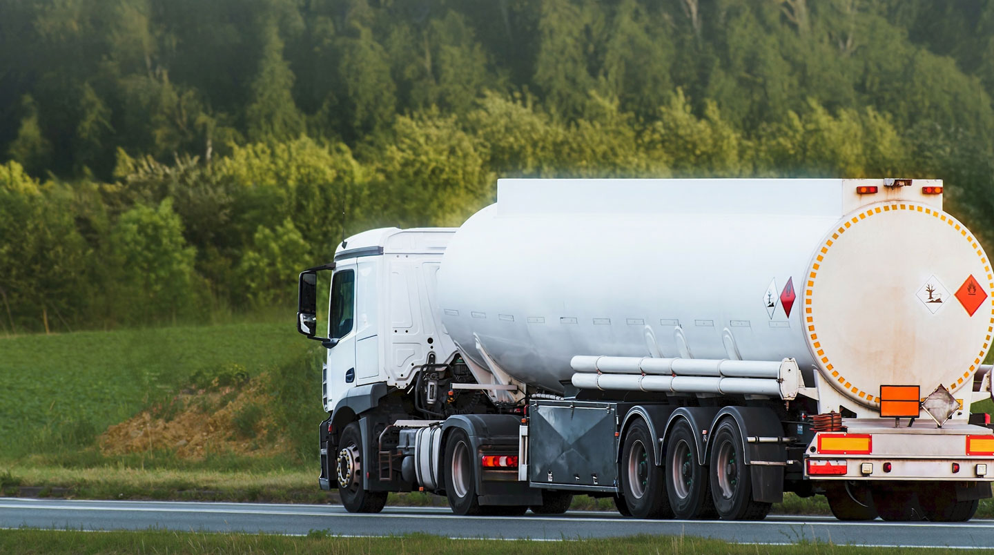 Une citerne propane blanche visible en arrière-plan d'un site agricole moderne français avec bâtiments propres et ciel dégagé